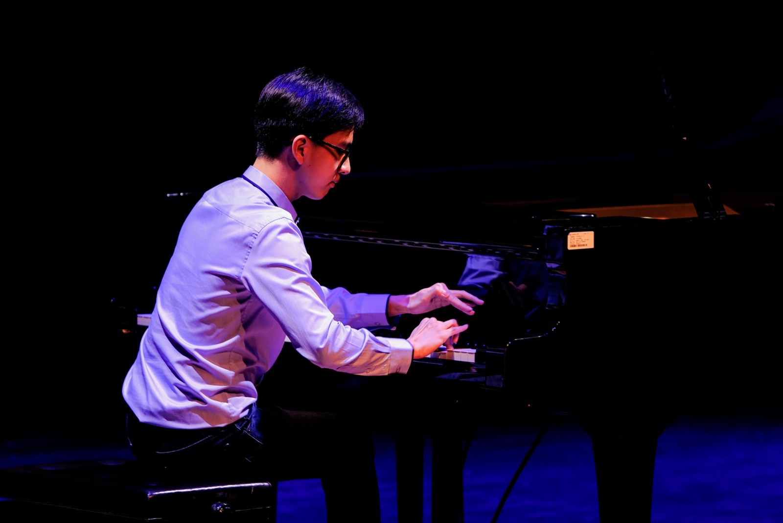 Close shot of Andrew Huang at the piano during a recital
